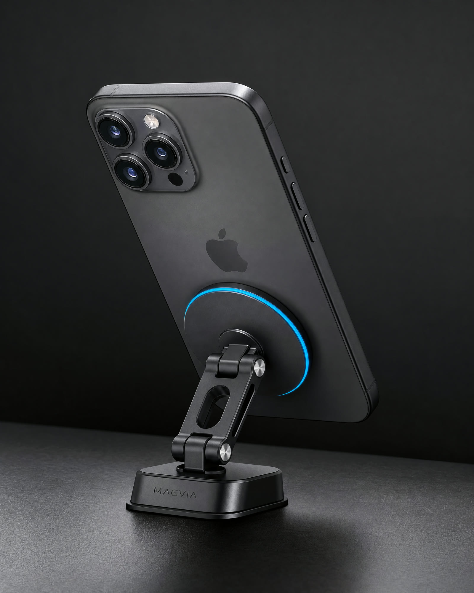Magvia Grip foldable magnetic car mount in matte black with a cyan magnetic ring, holding a phone